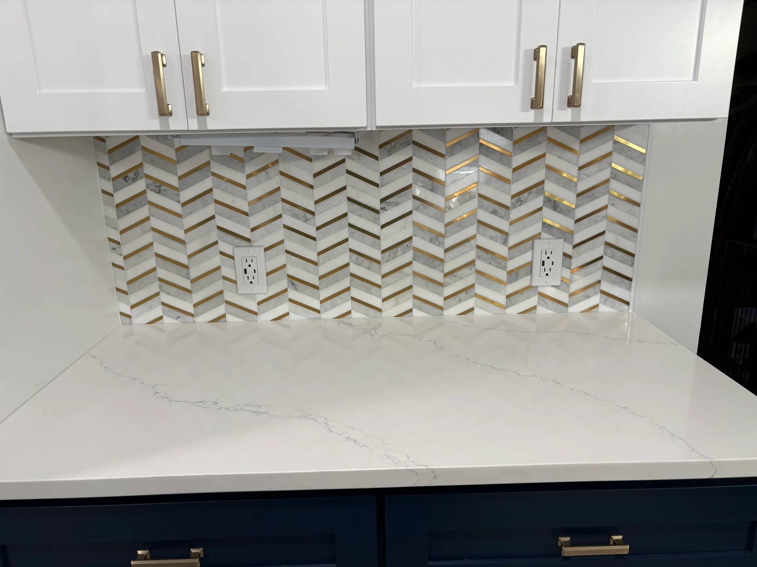 Kitchen countertop with chevron backsplash tiles.