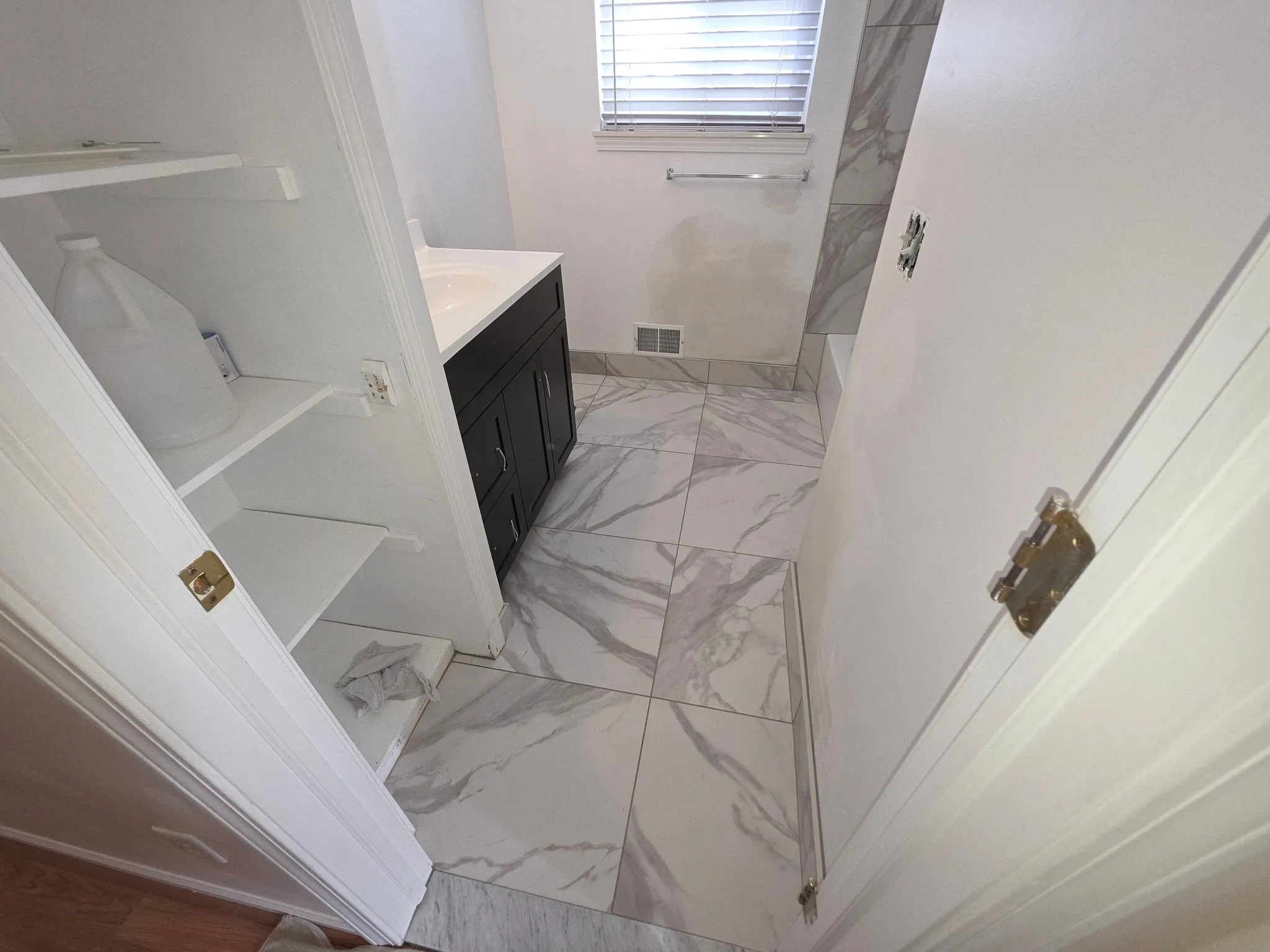Small bathroom with marble tile floor.