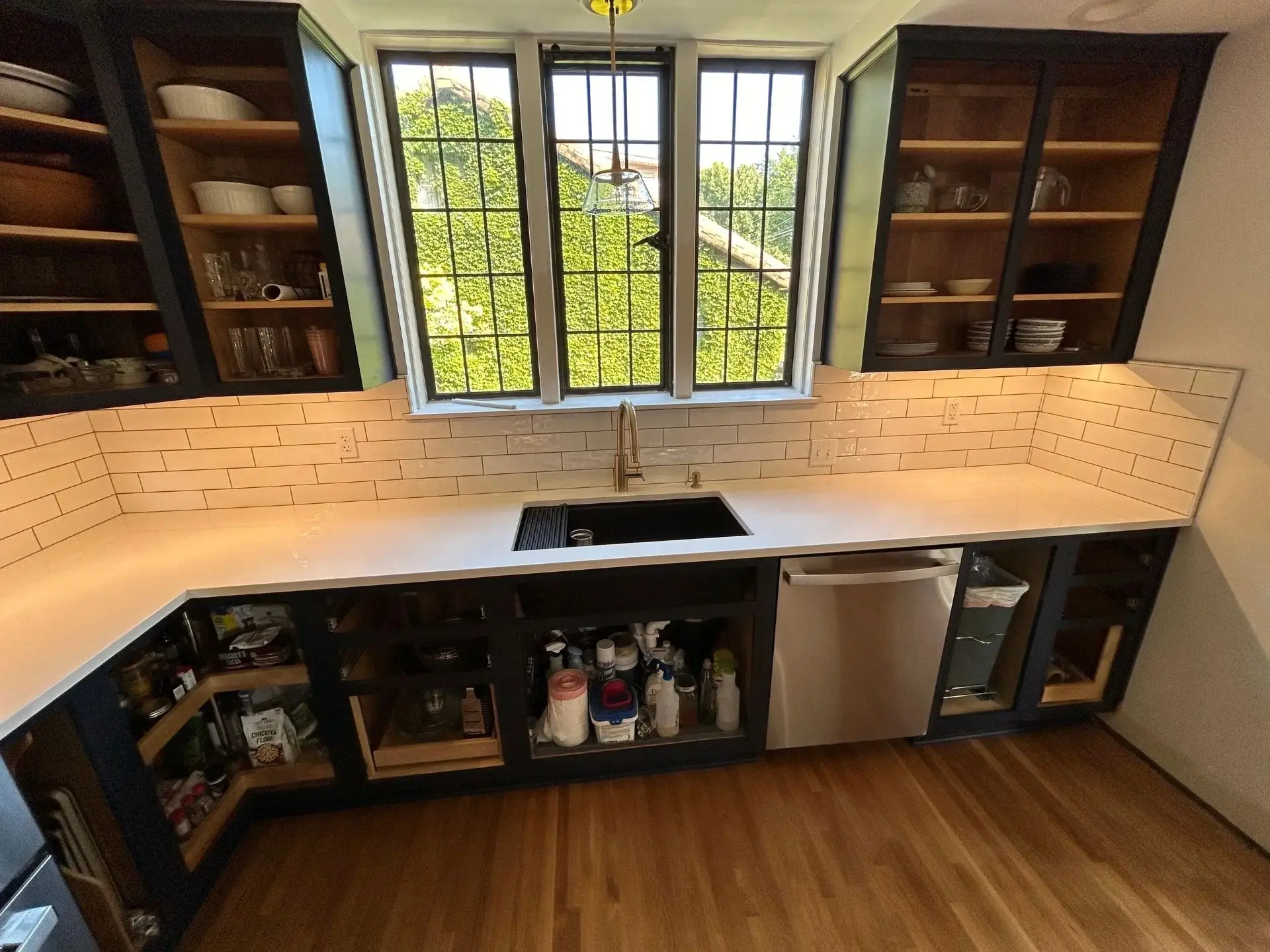 Modern kitchen with black cabinets and windows.